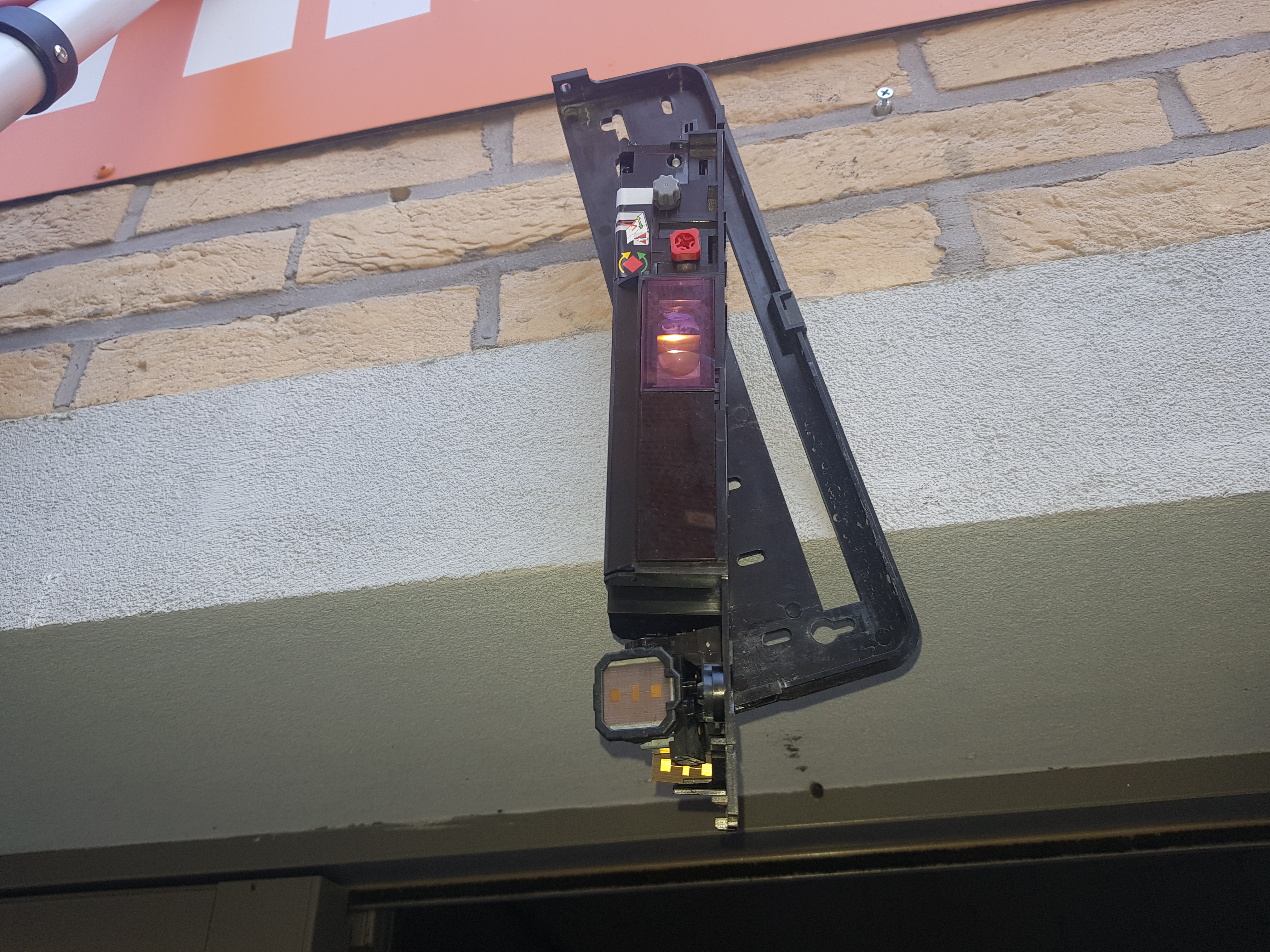 Capteur de mouvement décroché de son support avec voyant de défaut orange allumé — Basic-Fit Mons