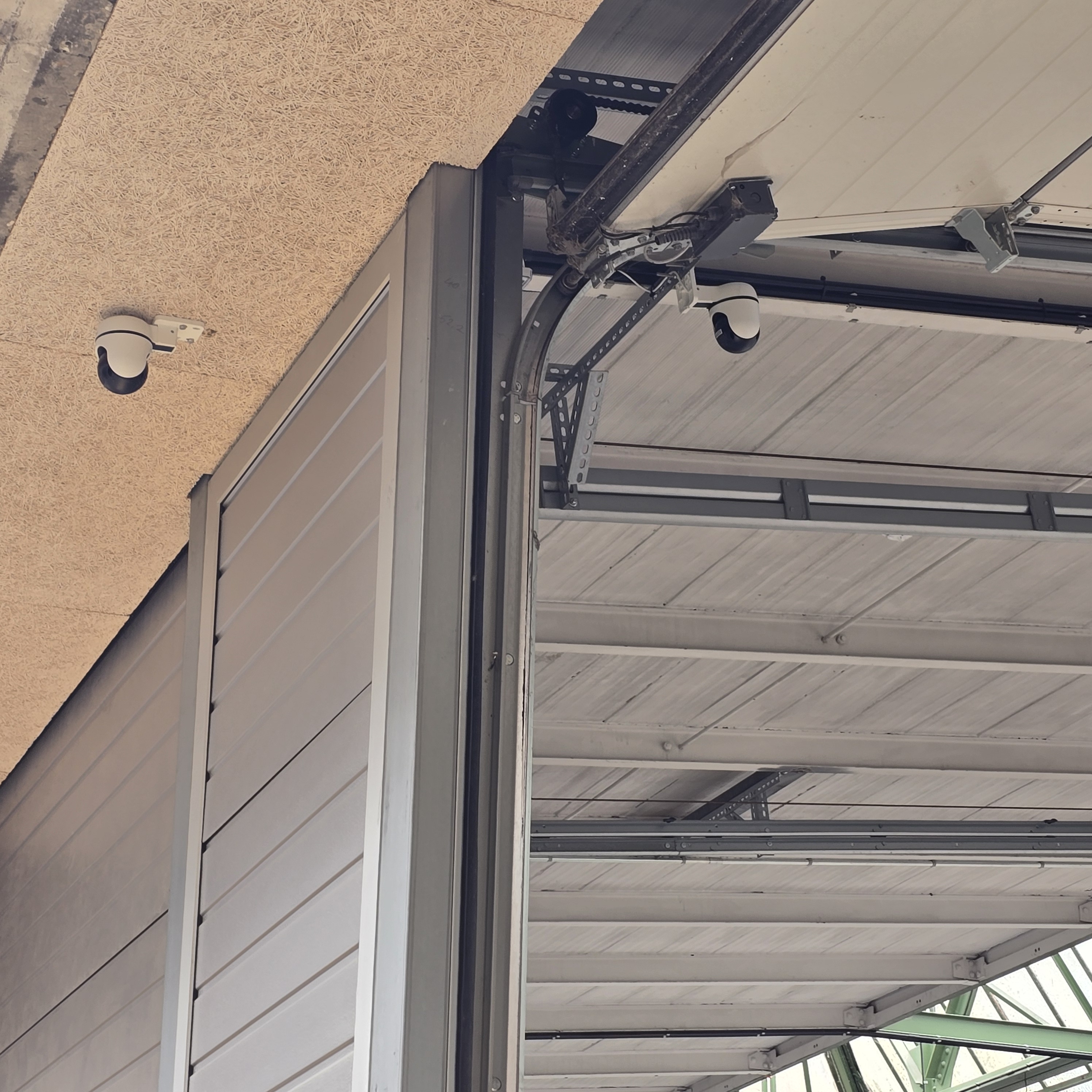 Deux caméras IP installées sous auvent industriel ASBL — système de vidéosurveillance ELECOMM