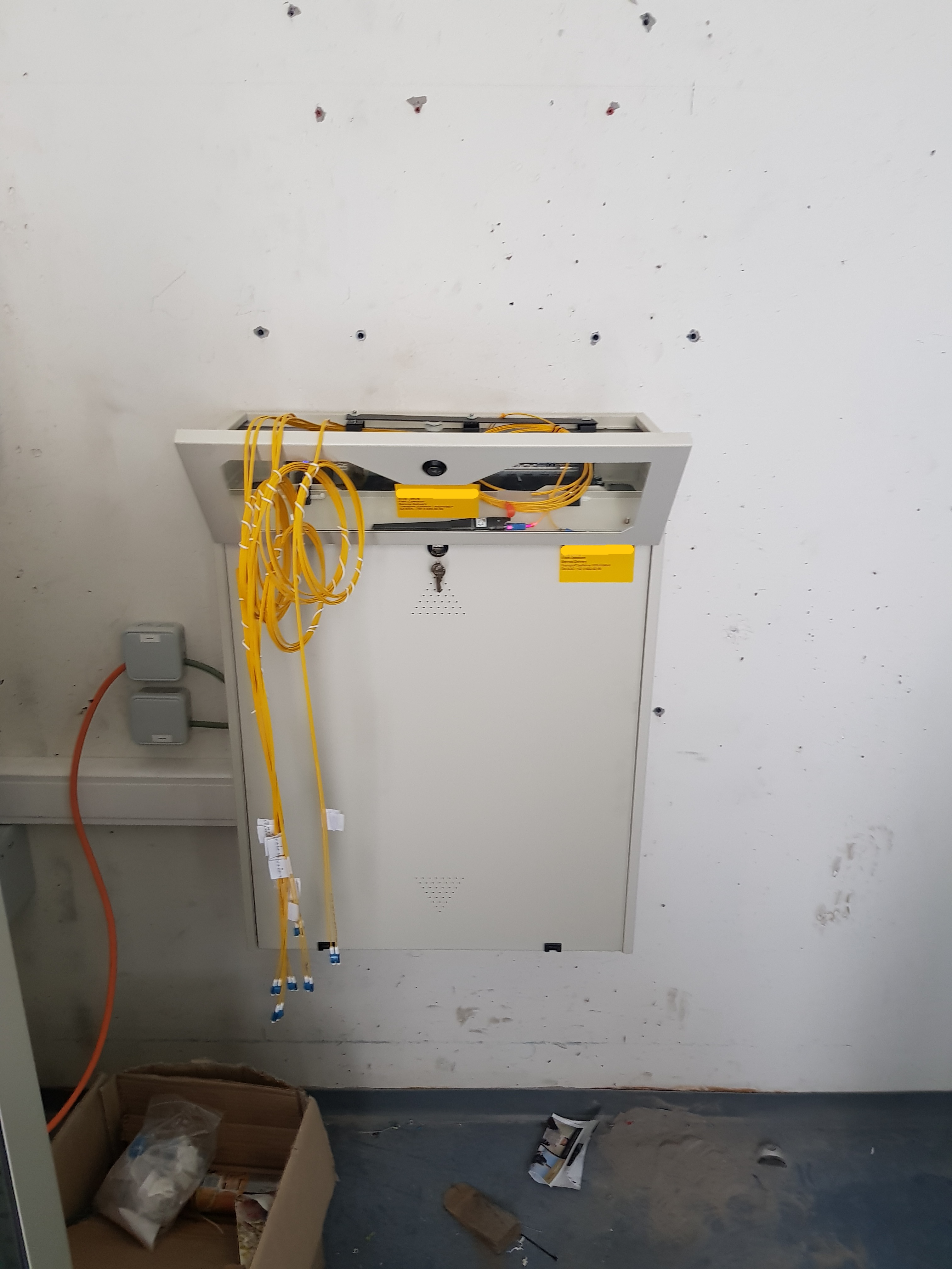 ODF mural fibre optique singlemode avec patch cords jaunes OS2 en cours d'installation — urgence ELECOMM