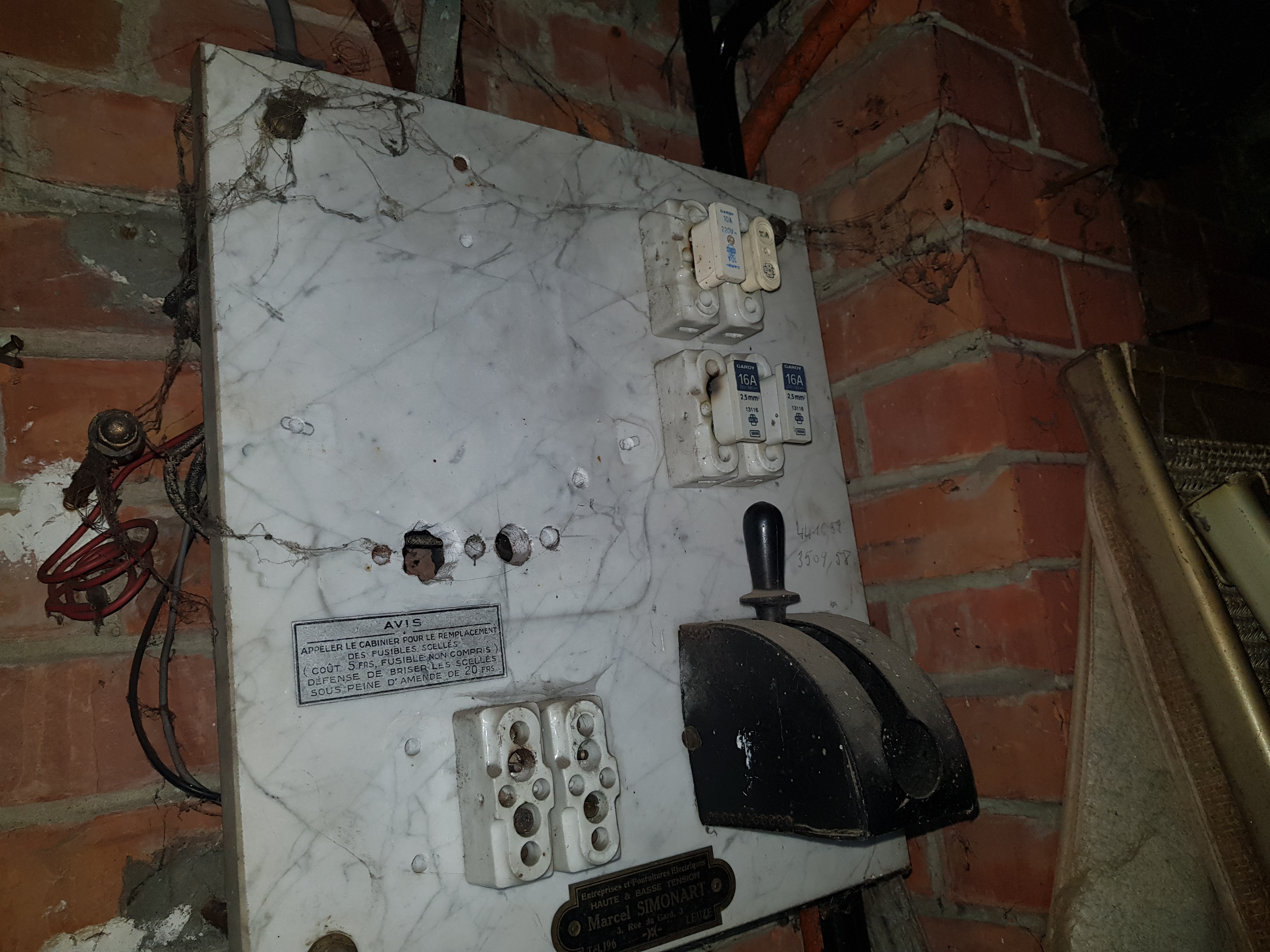 Tableau électrique sur plaque de marbre avec fusibles céramique, interrupteur à couteau et avis tarifaire en francs belges — Leuze-en-Hainaut